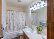 Thumbnail 14 of 20 - a bathroom with a sink and a toilet and a tub. Fargo, ND Martha Alice Apartments