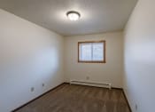 Thumbnail 12 of 20 - a bedroom of an empty house with a window and white walls. Fargo, ND Martha Alice Apartments