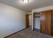 Thumbnail 13 of 20 - a bedroom with a closet and a door to a bathroom. Fargo, ND Martha Alice Apartments