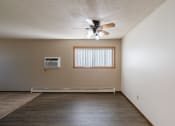 Thumbnail 11 of 20 - an empty living room with a ceiling fan and a window