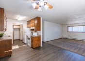 Thumbnail 8 of 20 - an empty living room with a kitchen and a ceiling fan. Fargo, ND Martha Alice Apartments