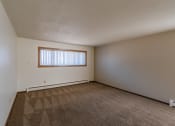 Thumbnail 7 of 20 - an empty living room with carpet and a window. Fargo, ND Martha Alice Apartments