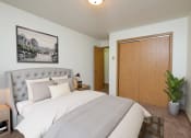 Thumbnail 7 of 26 - Fargo, ND Monticello. A bedroom with a large bed with white bedding and a closet for extra storage.