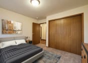 Thumbnail 7 of 31 - Fargo, ND Oxford Apartments. a bedroom with a bed and a wardrobe