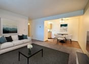Thumbnail 5 of 28 - a living room with a couch and a coffee table and a dining room and kitchen. Fargo, ND Pacific Park 2 Apartments
