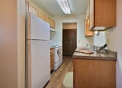 Thumbnail 16 of 28 - a kitchen with white appliances and wood cabinets. Fargo, Pacific Park II Apartments