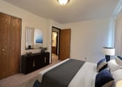 Thumbnail 3 of 18 - a bedroom with a bed and a dresser and a mirror. Fargo, ND Pacific South Apartments