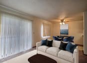 Thumbnail 1 of 18 - a living room with a white couch and a large window. Fargo, ND Pacific South Apartments