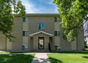 Thumbnail 1 of 20 - a brick building with a sidewalk in front of it and trees. Fargo, ND Park Circle Apartments.