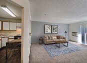 Thumbnail 1 of 25 - Open living room and kitchen with a couch and a table at Park Place Apartments in Fargo
