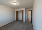 Thumbnail 7 of 16 - Fargo, ND Parkside Apartments. A bedroom with a carpeted floor and a door to a closet