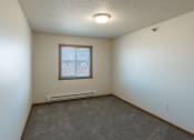 Thumbnail 8 of 16 - Fargo, ND Parkside Apartments. A bedroom with a window and carpet