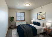 Thumbnail 3 of 16 - Fargo, ND Parkside Apartments. A bedroom with a large bed and a potted plant