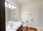 Thumbnail 8 of 23 - Bathroom with a white sink and toilet next to a white bathtub at Parkwest Gardens 58078
