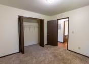 Thumbnail 7 of 23 - Bedroom with two closets and a carpeted floor at Parkwest Gardens West Fargo