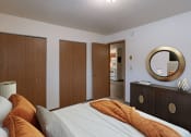 Thumbnail 3 of 10 - a bedroom with a bed and a dresser and a mirror. Fargo, ND Parkwood East and West Apartments