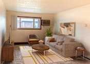 Thumbnail 1 of 19 - the living room of a small apartment with a couch and a chair. Fargo, ND Patricia Ann Apartments