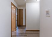 Thumbnail 16 of 19 - Fargo, ND Patricia Ann Apartments. A hallway with white walls and wood floors