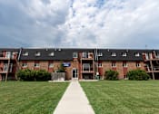 Thumbnail 19 of 19 - Fargo, ND Patricia Ann Apartments. A pathway leading to a brick building with balconies