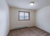 Thumbnail 25 of 36 - bedroom of an empty apartment with carpet and a window. Fargo, ND Place One Apartments