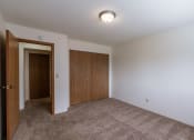 Thumbnail 24 of 36 - an empty living room with carpet and a door to a closet. Fargo, ND Place One Apartments