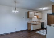 Thumbnail 22 of 36 - an empty kitchen with wood floors and white walls. Fargo, ND Place One Apartments