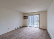 Thumbnail 18 of 36 - the living room of an apartment with a large window and carpeting. Fargo, ND Place One Apartments