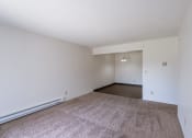 Thumbnail 19 of 36 - the living room and dining room of an apartment with carpet and white walls. Fargo, ND Place One Apartments