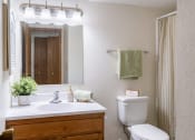 Thumbnail 31 of 36 - a bathroom with a toilet and a sink and a mirror. Fargo, ND Place One Apartments