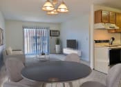 Thumbnail 5 of 36 - A living room with a table and chairs and a kitchen with a television. Fargo, ND Place One Apartments.