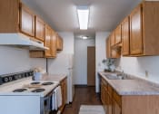 Thumbnail 29 of 36 - a kitchen with wood cabinets and white appliances and a counter top. Fargo, ND Place One Apartments