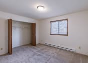 Thumbnail 13 of 36 - the living room of an empty house with a closet and a window. Fargo, ND Place One Apartments