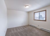 Thumbnail 16 of 36 - a bedroom of an apartment with carpet and a window. Fargo, ND Place One Apartments