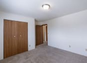 Thumbnail 15 of 36 - a bedroom with white walls and a door to a hallway. Fargo, ND Place One Apartments