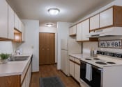 Thumbnail 11 of 36 - a kitchen with white appliances and wooden cabinets. Fargo, ND Place One Apartments