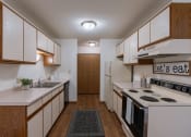Thumbnail 9 of 36 - a kitchen with white appliances and wooden cabinets. Fargo, ND Place One Apartments