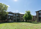 Thumbnail 35 of 36 - An exterior view of a brick apartment building with green grass. Fargo, ND Place One Apartments.