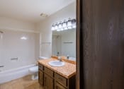 Thumbnail 12 of 14 - a bathroom with a sink and a toilet and a mirror. Fargo, ND Plumtree Apartments