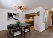 Thumbnail 2 of 14 - a dining area with a table and chairs and a ceiling fan. Fargo, ND Plumtree Apartments
