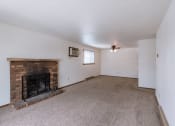 Thumbnail 4 of 14 - a living room with a brick fireplace and a carpeted floor. Fargo, ND Plumtree Apartments
