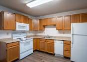 Thumbnail 25 of 32 - an empty kitchen with white appliances and wooden cabinets