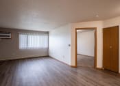 Thumbnail 24 of 32 - a living room with wood flooring and a door to a bedroom. Fargo, ND  Prairie Park Apartments