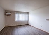 Thumbnail 23 of 32 - the living room of an empty apartment with wood flooring and a window