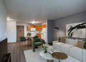 Thumbnail 6 of 32 - a living room and kitchen with a white couch and a table. Fargo, ND Prairie Park Apartments
