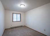 Thumbnail 16 of 32 - a bedroom with white walls and a window. Fargo, ND  Prairie Park Apartments