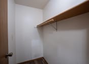 Thumbnail 21 of 32 - a walk in closet with a wooden rail and a white wall. Fargo, ND  Prairie Park Apartments