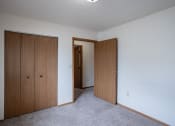 Thumbnail 11 of 32 - a bedroom with two closet doors and a door to a hallway. Fargo, ND  Prairie Park Apartments