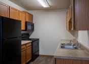 Thumbnail 8 of 32 - an empty kitchen with a sink and a refrigerator. Fargo, ND  Prairie Park Apartments