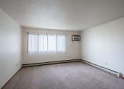 Thumbnail 7 of 32 - the living room of an empty house with white walls and a window. Fargo, ND  Prairie Park Apartments