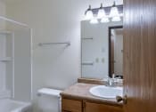 Thumbnail 20 of 21 - a bathroom with a sink and a mirror and a shower. Fargo, ND Prairiewood Courts Apartments